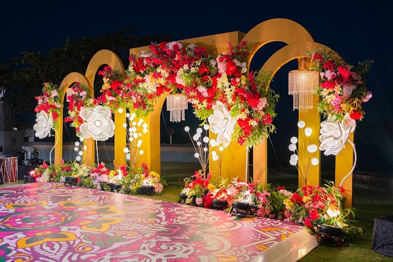 Empty Sangeet stage with red florals and gold arches by STHIRA DECOR