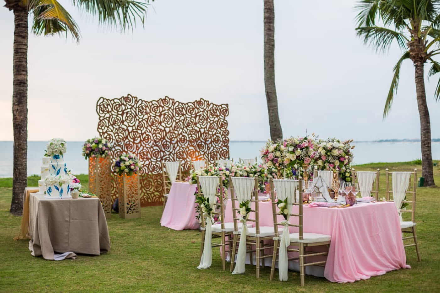 Outdoor coastal wedding reception with floral backdrop by CITTA